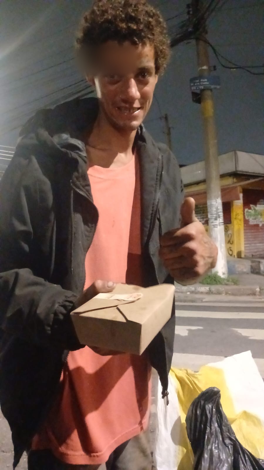 Beneficiário segurando uma refeição do Comida Sem Mesa