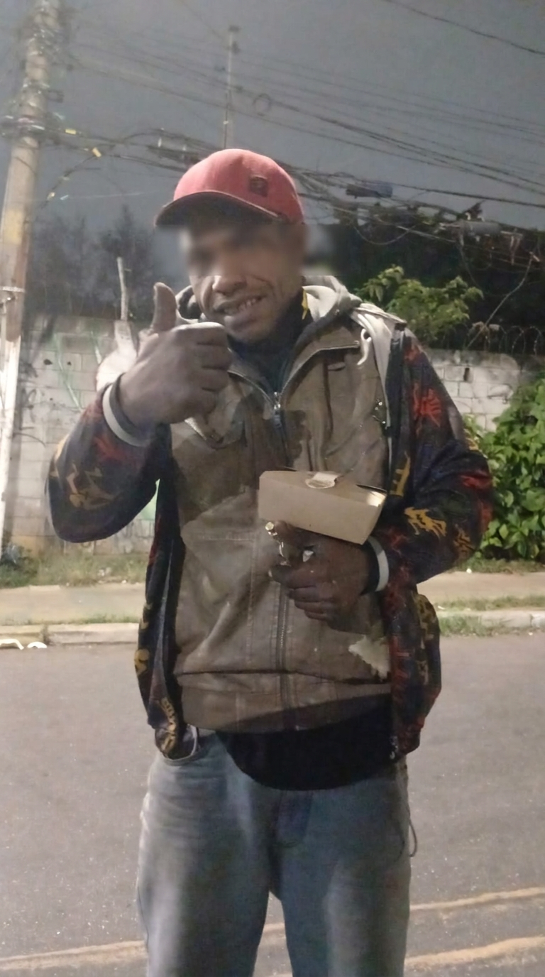 Beneficiário com uma refeição durante uma entrega noturna
